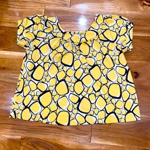 1X geometric yellow white and black shirt.